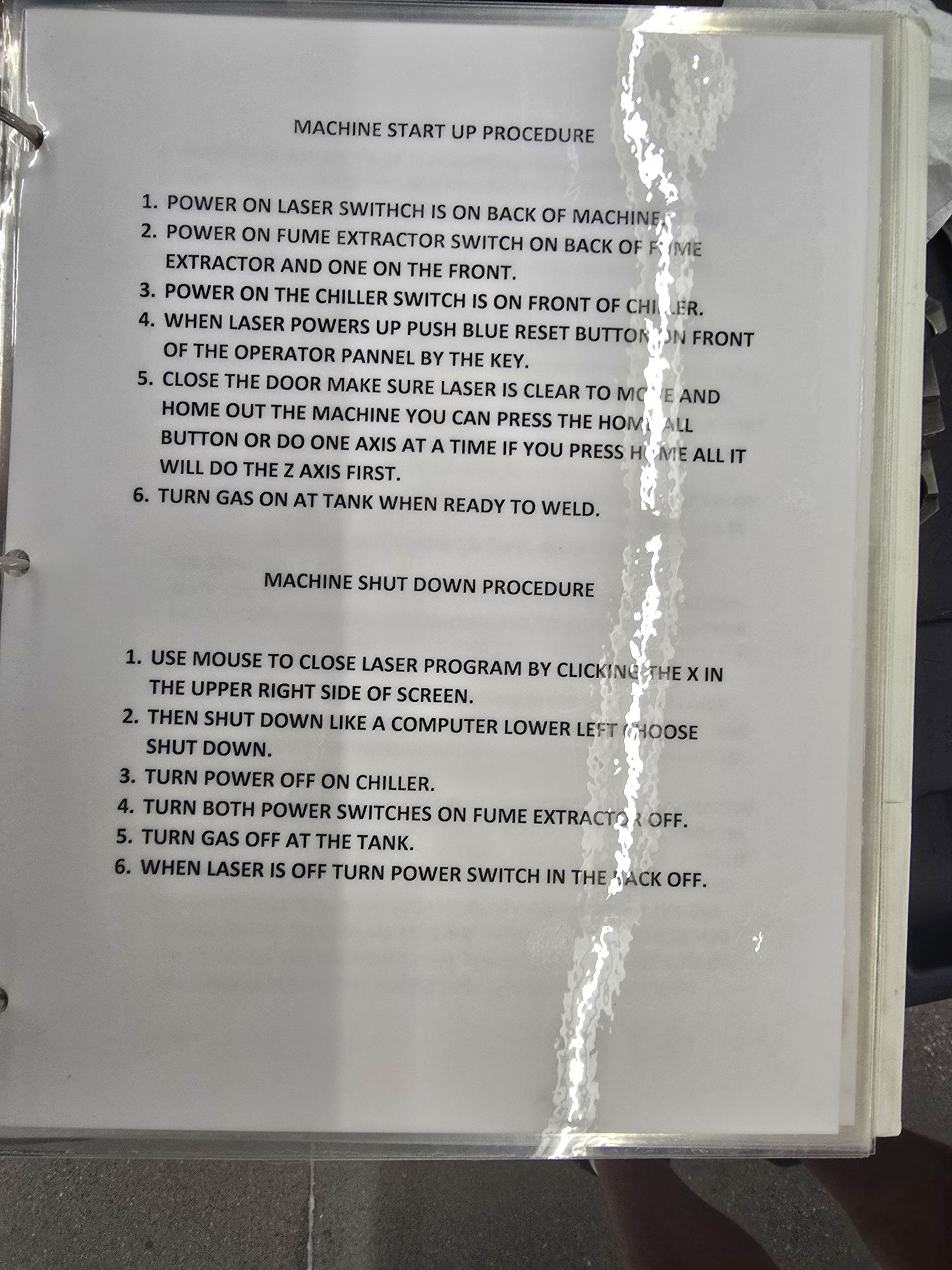 Laminated page in the SME's binder headed MACHINE START UP PROCEDURE, six numbered steps, above a MACHINE SHUT DOWN PROCEDURE of six more.